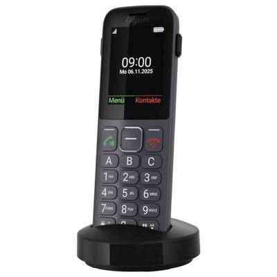 Ein schnurloses Telefon mit Tastatur und digitalem Display, das '09:00 Mo 06.11.2025' anzeigt. Es ist auf einer Ladestation montiert.