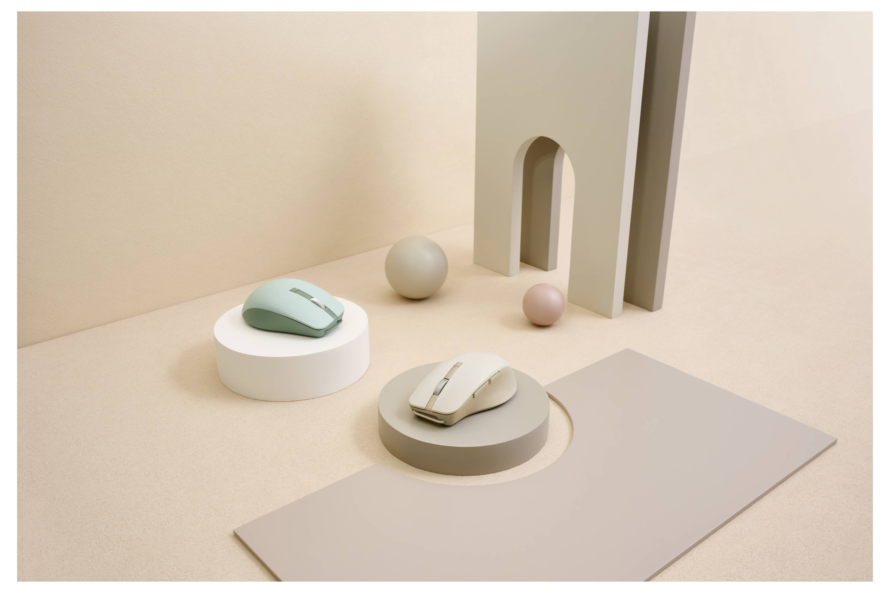 Computer-Mäuse, die auf geometrischen Sockeln präsentiert werden, mit minimalistischen, pastellfarbenen Kugeln und Strukturen, die eine künstlerische Komposition bilden.