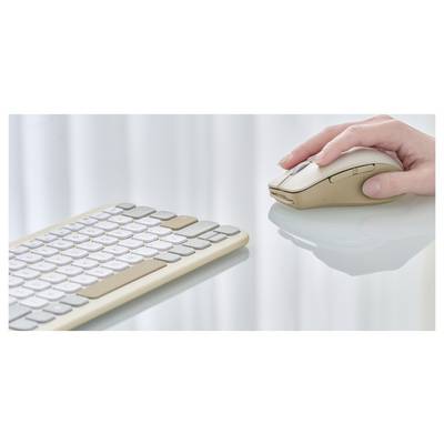 Eine Hand bedient eine beige drahtlose Computermaus neben einer passenden, schlanken Tastatur auf einer reflektierenden Oberfläche.