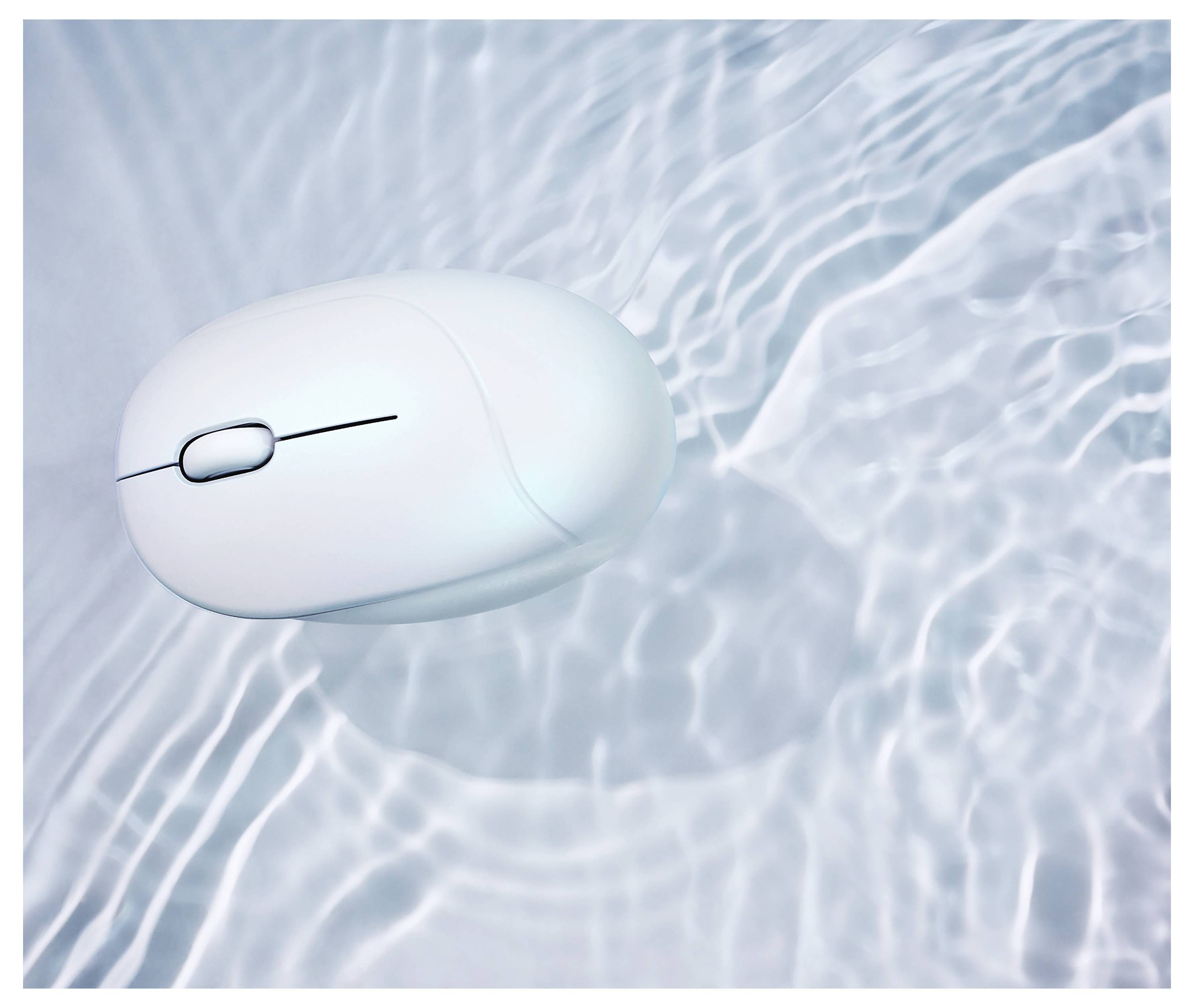 Eine weiße Computermaus schwebt über texturierten Wasserrippen und wirft einen Schatten auf die Oberfläche.