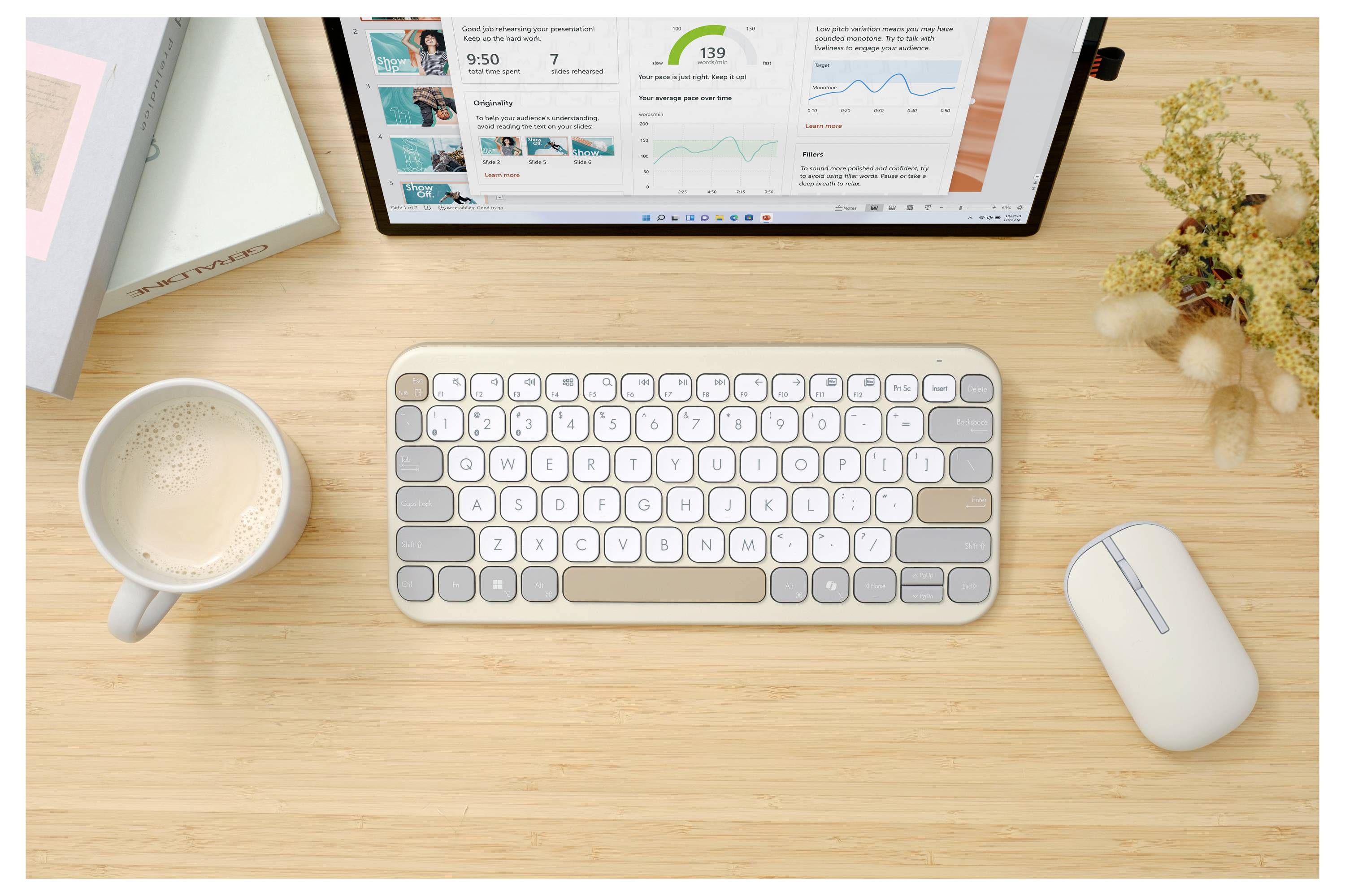 Ein minimalistischer Arbeitsbereich mit einem Tablet mit Diagrammen, einer drahtlosen Tastatur und Maus, einer Kaffeetasse und einer kleinen Topfpflanze auf einem Holzschreibtisch.