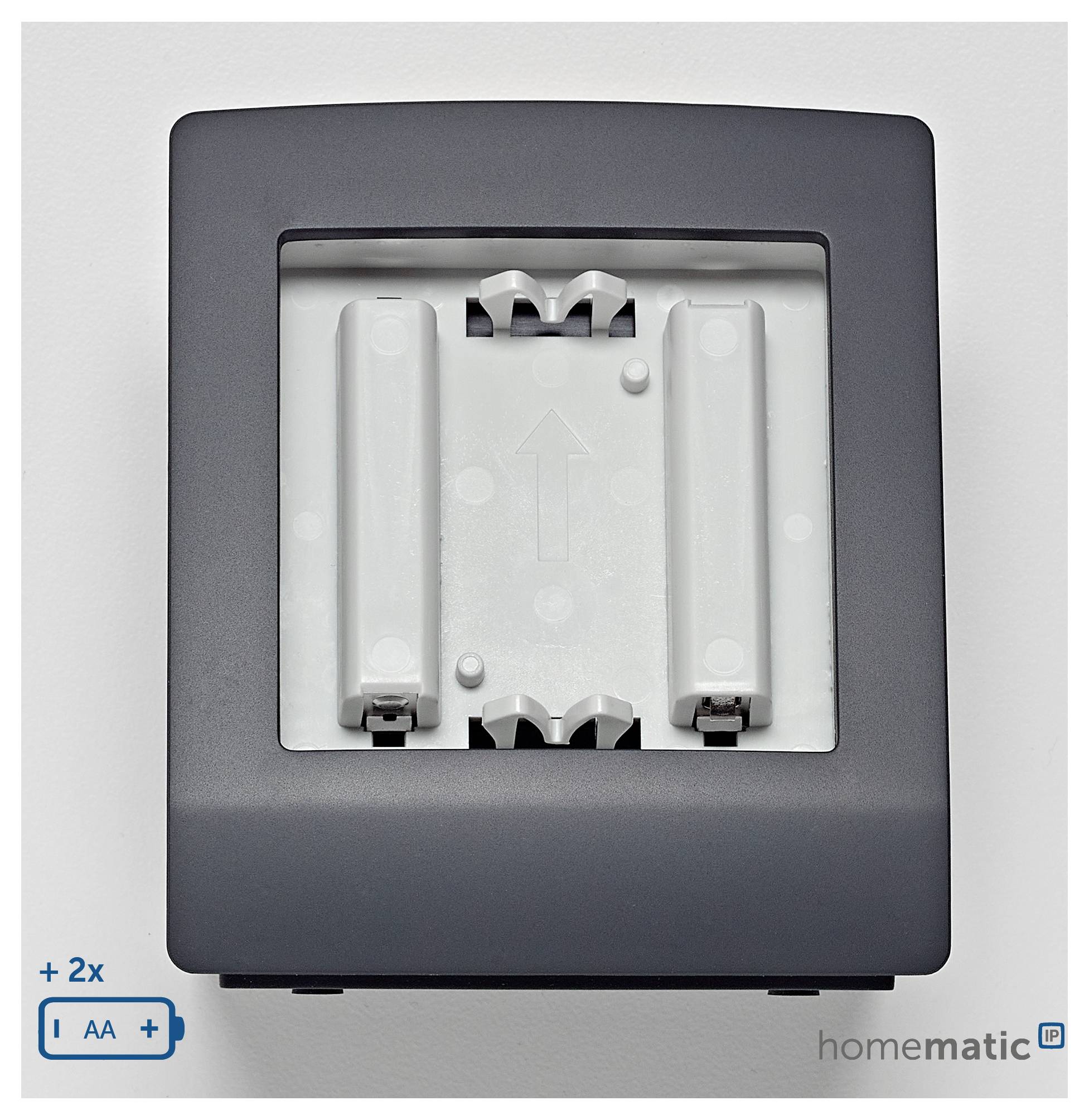 Eine wandmontierte, batteriebetriebene Gerätehülle mit Einschubplätzen für zwei AA-Batterien, mit Pfeil zur Batterieausrichtung, Marke 'homematic'.
