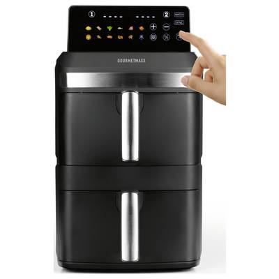 Ein Doppelkorb-Heißluftfritteur steht auf einer Küchenarbeitsplatte und zeigt ein digitales Display mit Kocheinstellungen. In der Nähe befinden sich auf Tellern gebratenes Hähnchen, Pommes und gefüllte Paprikaschoten.