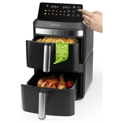Ein Dual-Korb-Heißluftfriteuse mit gegrilltem Gemüse in einem Korb und gekochten Kartoffelecken im anderen, die die Vielseitigkeit des Geräts zeigt.