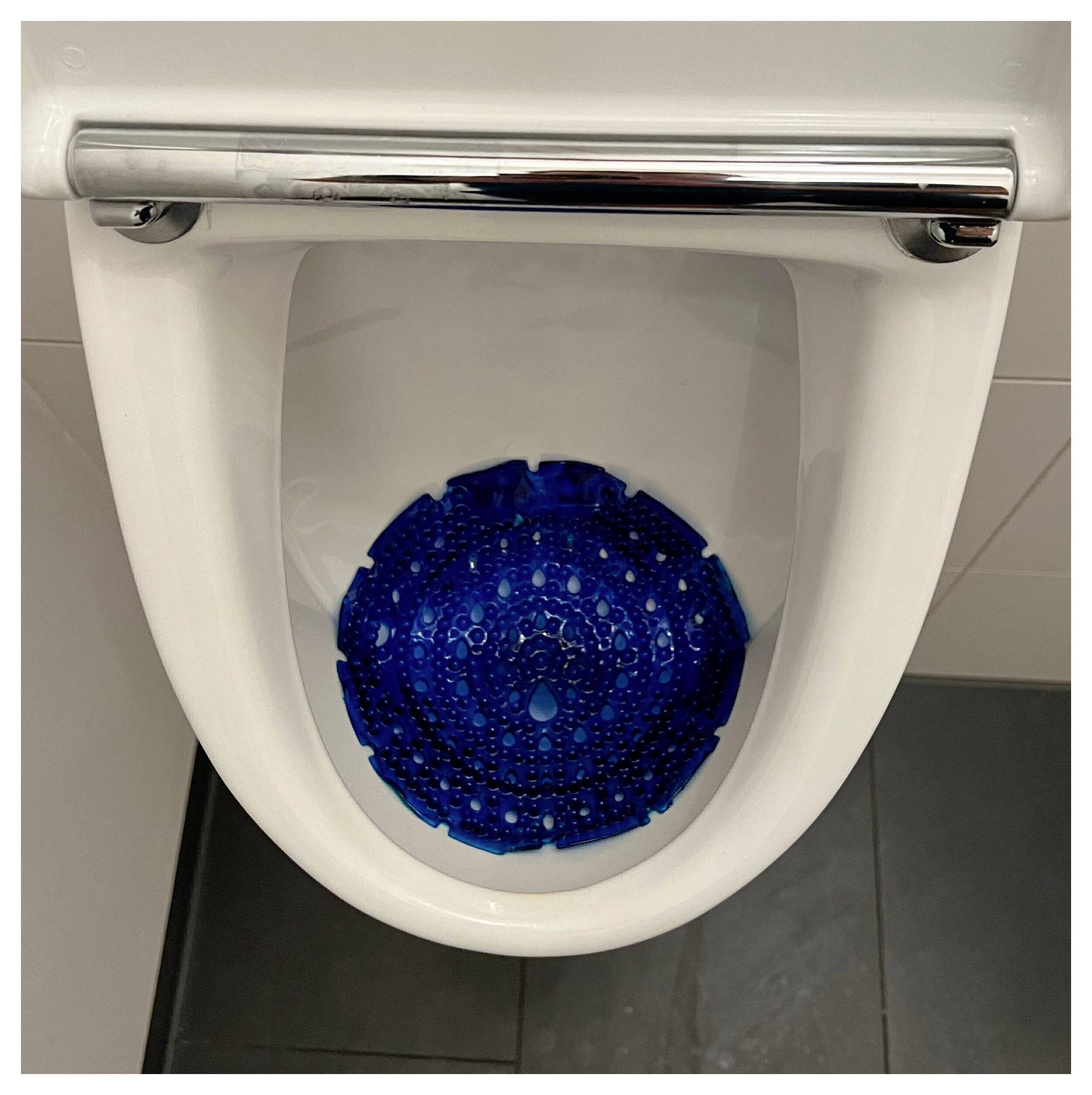 Ein Urinal mit einem blauen Geruchsneutralisierer-Pad an der Basis.