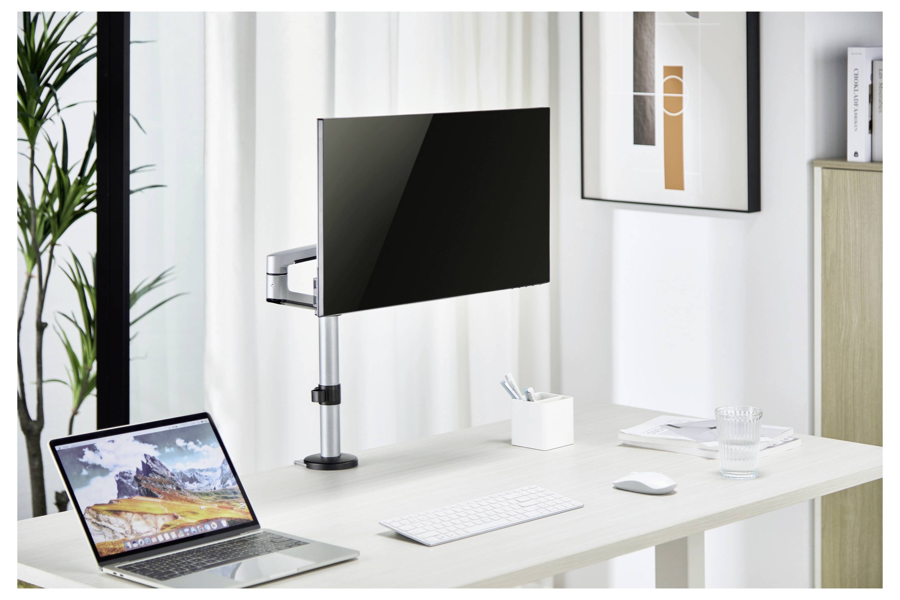 Ein minimalistisches Bürotisch-Setup mit einem Laptop, einem angebrachten Monitor, einer Tastatur, einer Maus und einer kleinen Pflanze, angesiedelt in einem hellen, zeitgenössischen Raum.