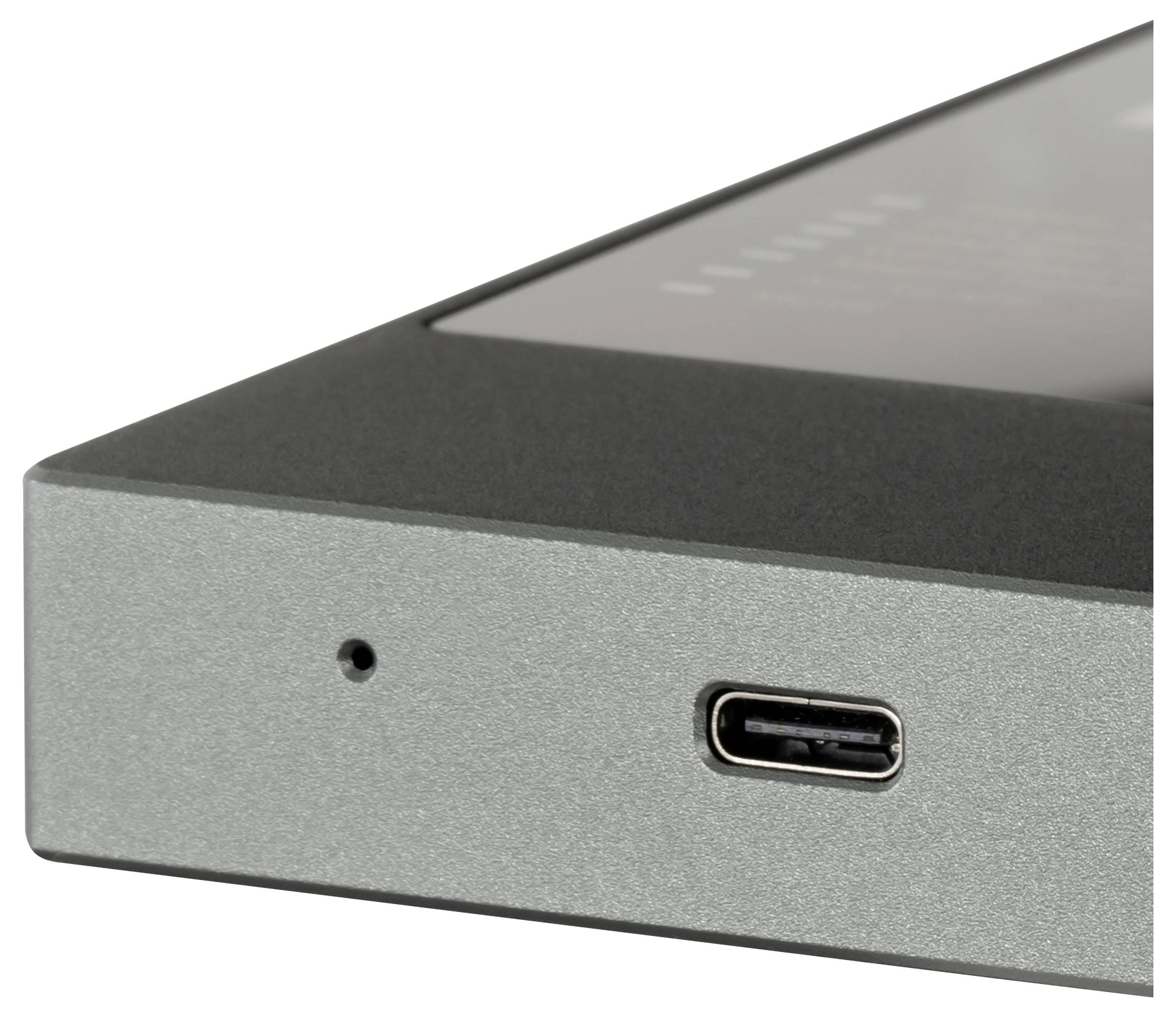 Nahaufnahme einer Ecke eines grauen elektronischen Geräts, die ein kleines Loch und einen USB-C-Anschluss auf der Frontplatte zeigt.