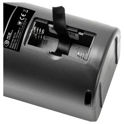 Nahaufnahme eines Batteriefachs an einem schwarzen Gerät, das Federkontakte und eine Lasche zum Einsetzen oder Entfernen von Batterien zeigt.