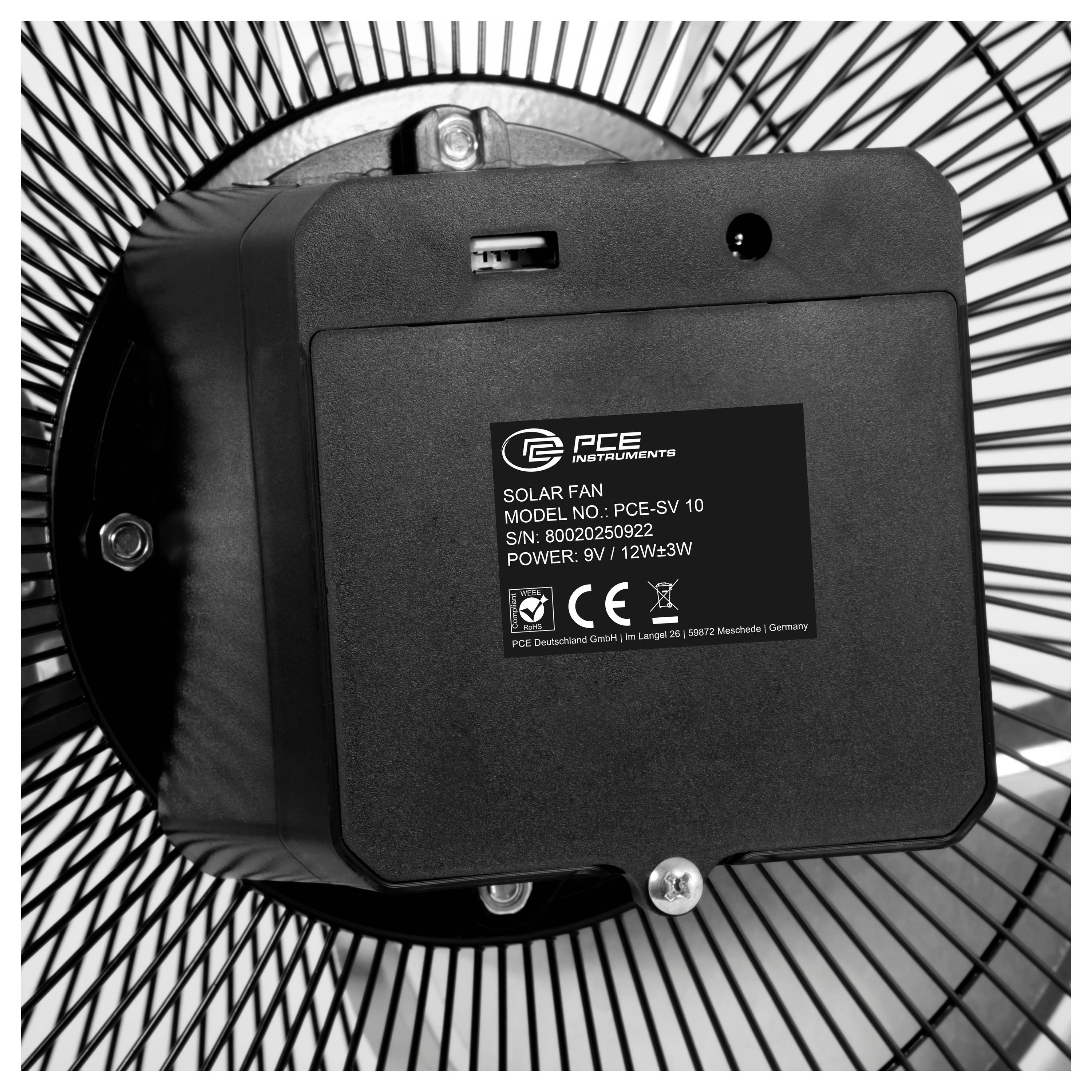 Nahaufnahme des Motorgehäuses eines PCE Instruments Solarlüfters und Etikett, montiert in der Mitte einer drahtgebundenen Lüfterschutzvorrichtung.