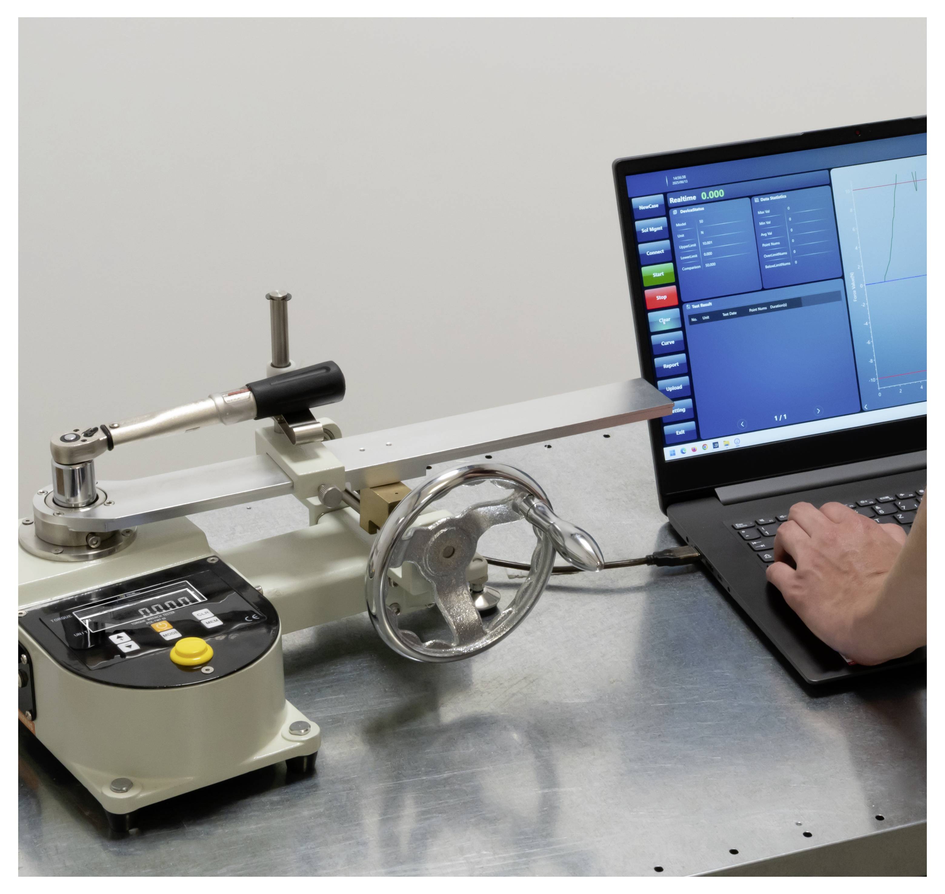 Ein Techniker bedient einen Laptop, der mit einer mechanischen Prüfmaschine mit einem rotierenden Rad und einem Messhebel verbunden ist, und überwacht die Daten auf dem Bildschirm.