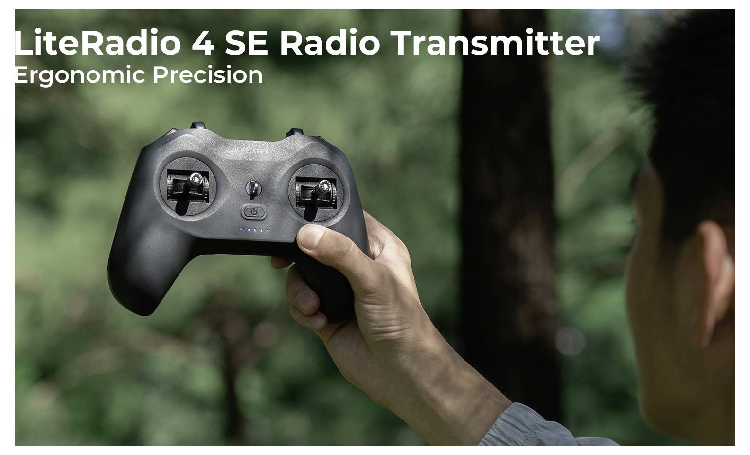 Person hält einen LiteRadio 4 SE Funkfernsteuerungs-Sender draußen, mit Text im Bild "LiteRadio 4 SE Funkfernsteuerungs-Sender" und "Ergonomische Präzision".