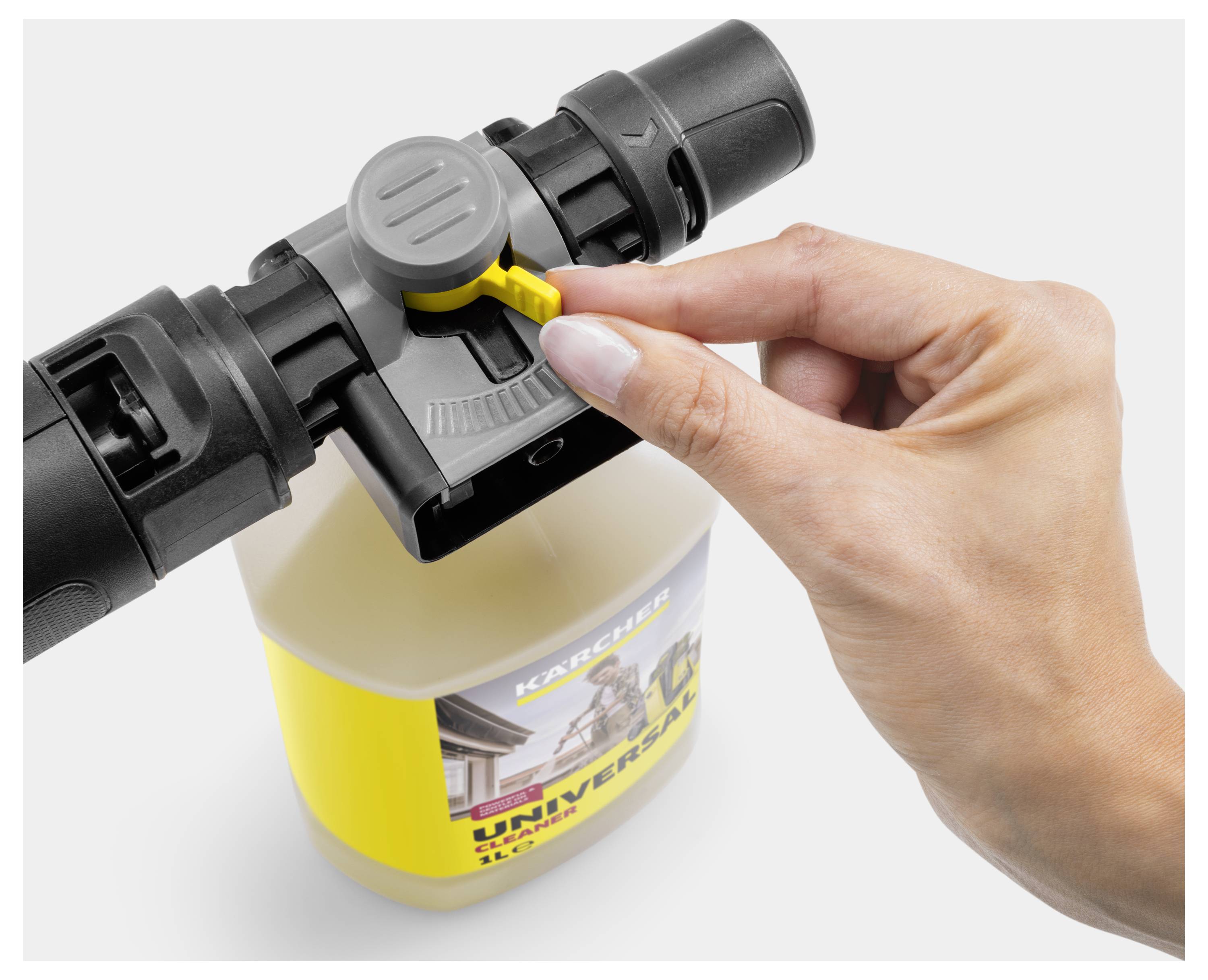 Eine Hand stellt den Regler auf einer Reinigungsmittelflasche ein, die an einem Sprühschlauch befestigt ist, und zeigt damit die Gebrauchsanweisungen für die Reinigungsausrüstung an.