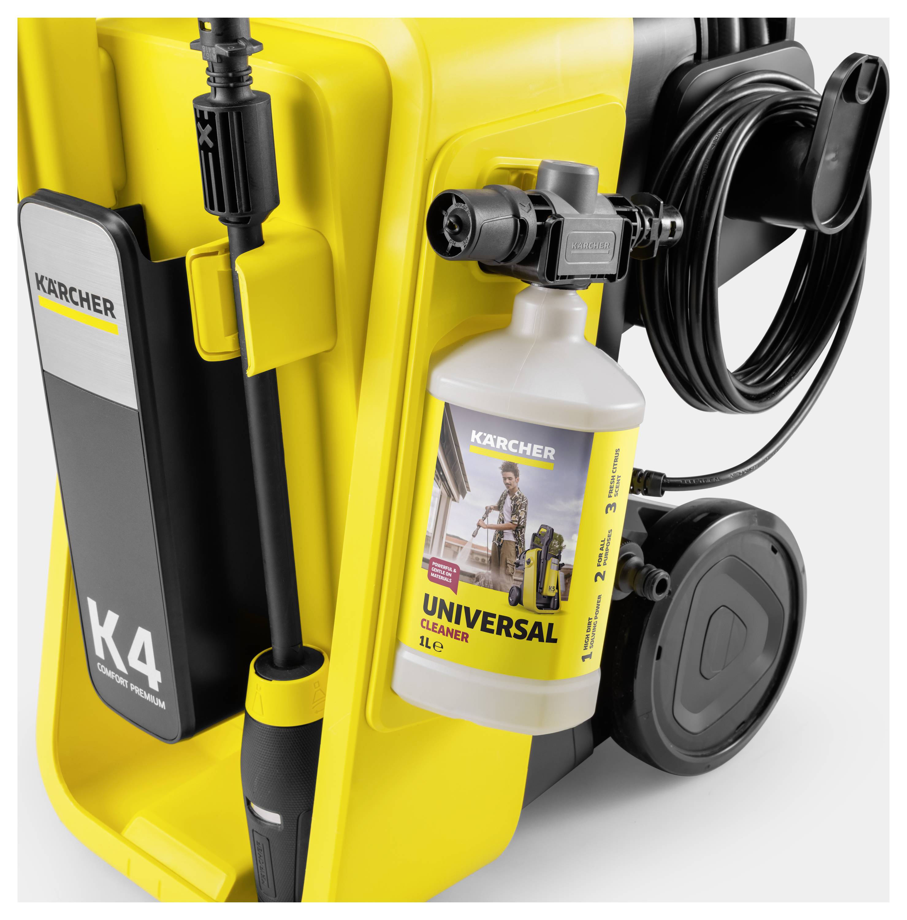 Ein gelber Kärcher K4 Hochdruckreiniger mit angebrachter Reinigerflasche mit der Aufschrift „Universal Cleaner". Ausgestattet mit Schlauch und Zubehör.