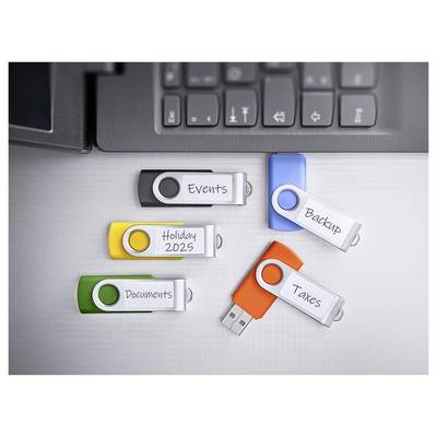 Fünf USB-Laufwerke mit den Beschriftungen „Events", „Holiday 2025", „Documents", „Backup" und „Taxes" sind neben einer Laptop-Tastatur angebracht.