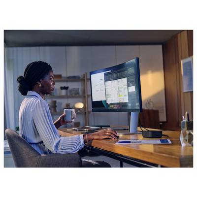 Eine Person sitzt an einem Schreibtisch und arbeitet an einem Computer, während sie eine Kaffeetasse hält. Der Bildschirm zeigt ein offenes Dokument in einem organisierten Arbeitsbereich.