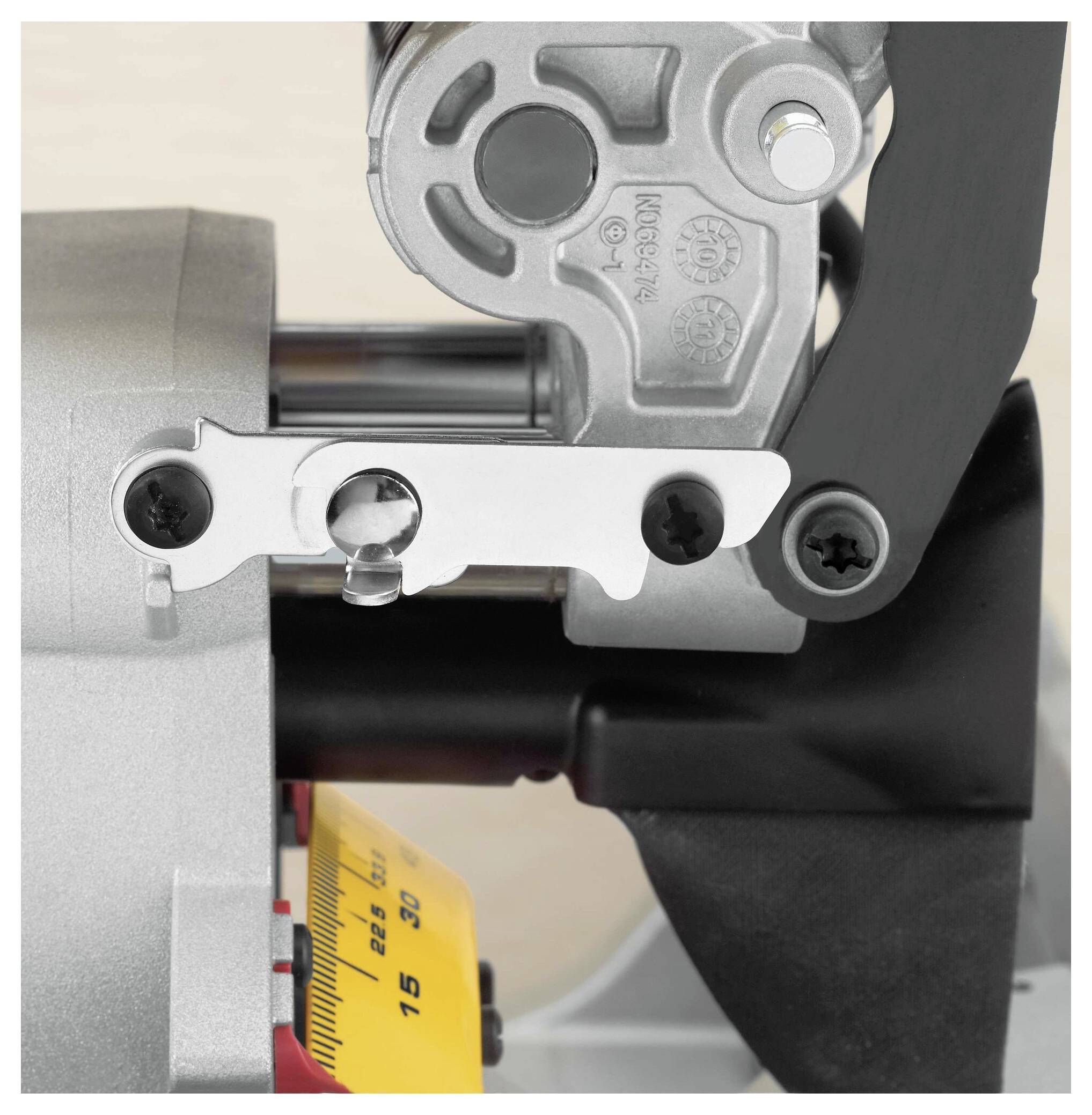 Eine Nahaufnahme einer mechanischen Komponente mit Zahnrädern, Schrauben und einem Messgerät, das in Schritten von 0 bis 15 beschriftet ist, möglicherweise zur Anzeige der Spannung.