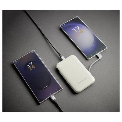 Eine weiße Powerbank, die zwei Smartphones lädt, beide zeigen einen Akkustand von „24 %", verbunden mit schwarzen Kabeln auf einer grauen Oberfläche.