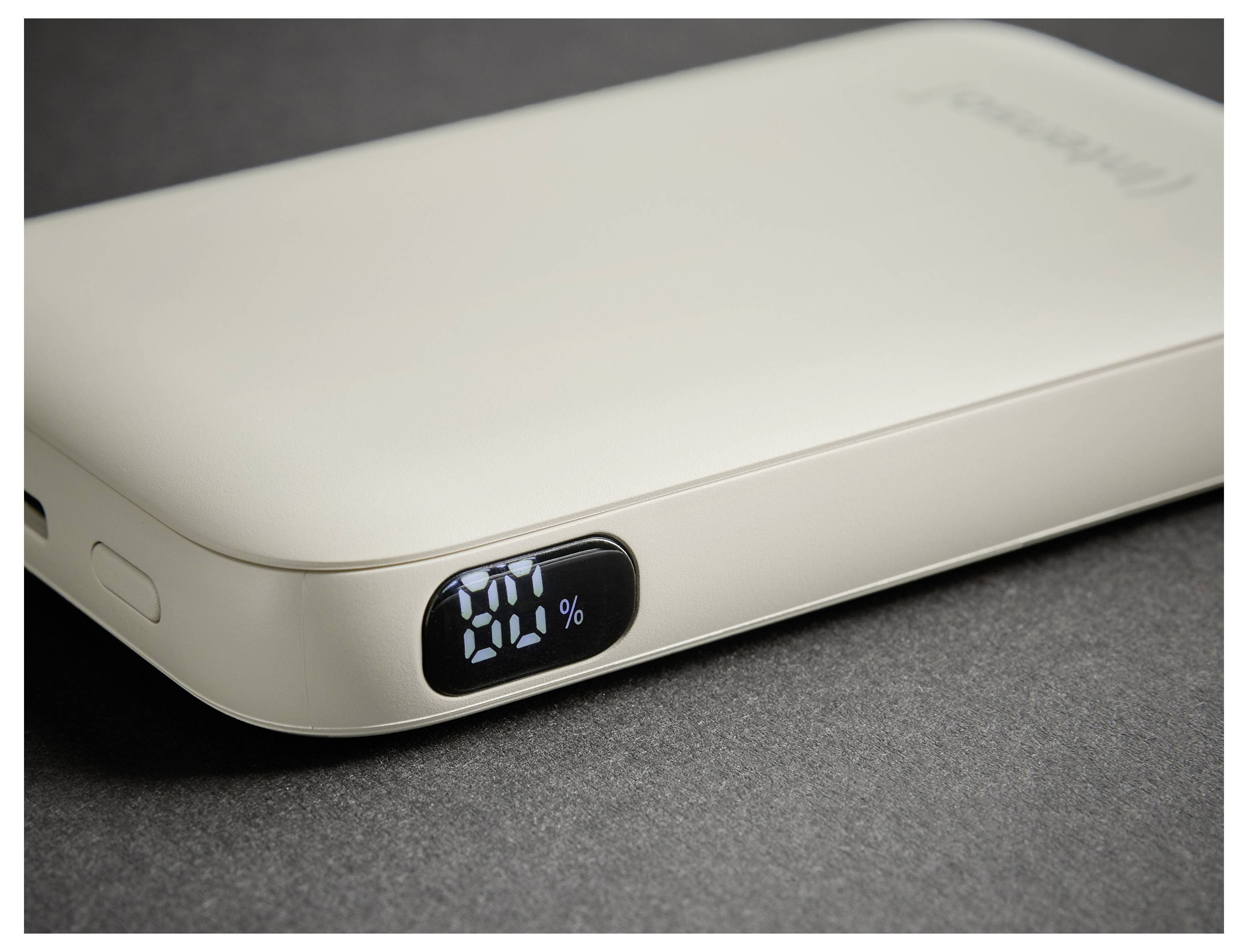 Eine beige tragbare Powerbank mit digitaler Anzeige, die „20%" anzeigt.