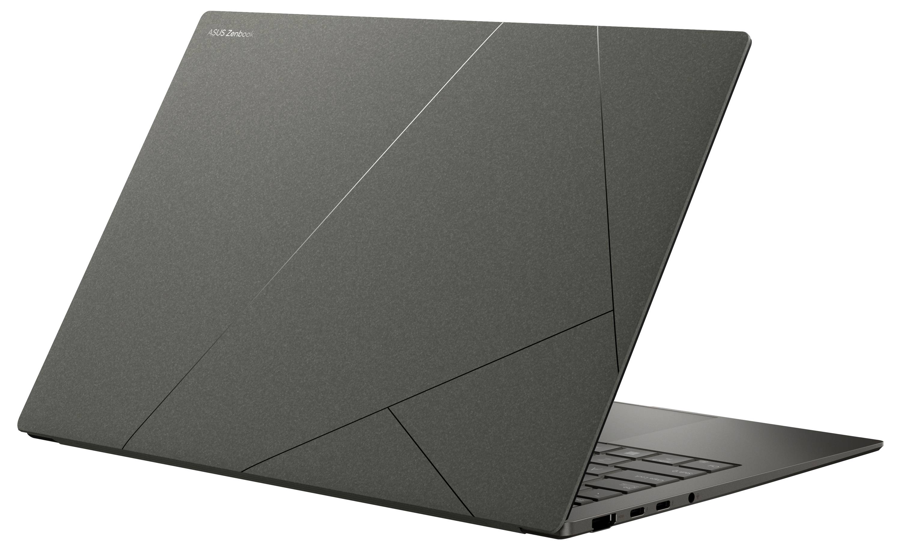 Ein schlanker, dünner Laptop mit geometrischem Muster auf der Rückseite, auf einer ebenen Fläche positioniert, zeigt sein Seitenprofil und die Tastatur.