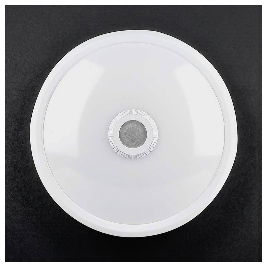 Ein runder, weißer Rauchmelder mit einem zentralen Sensor, der auf einer dunklen Oberfläche montiert ist.