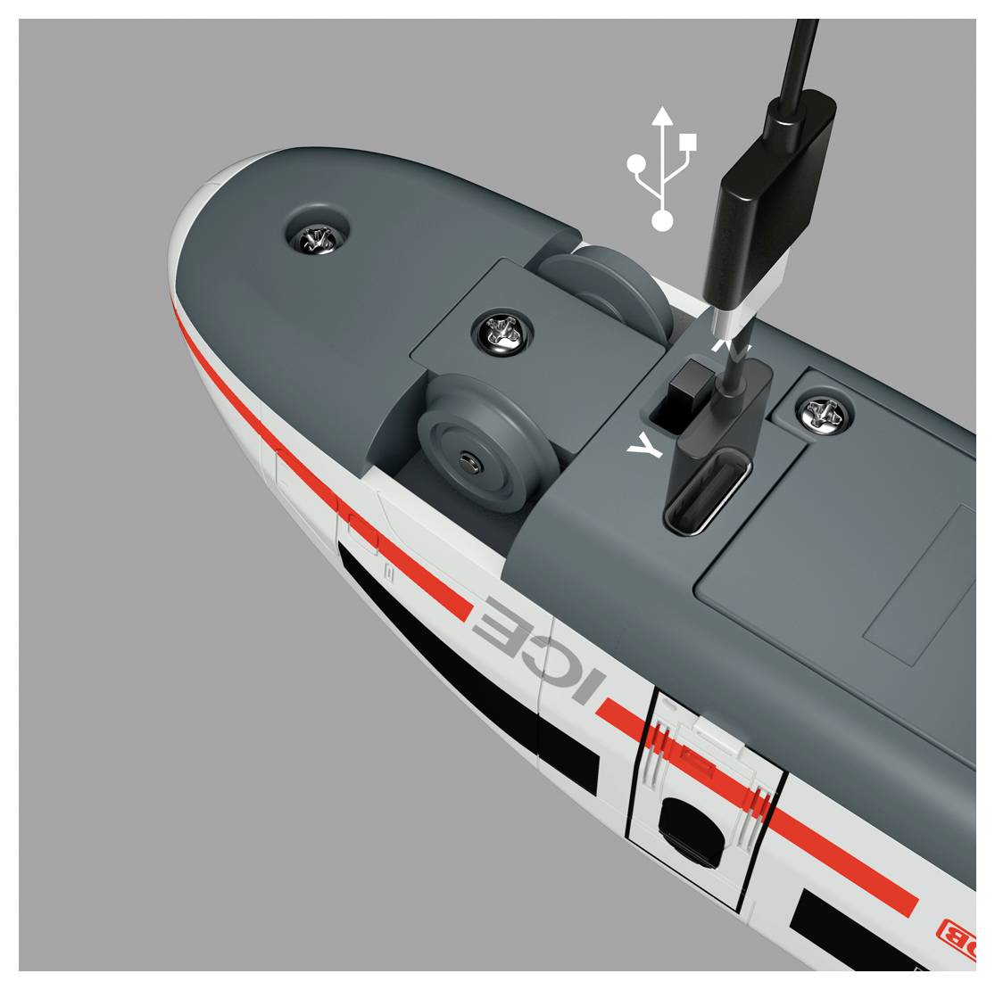 Ein grau-weißer Spielzeugzug, beschriftet mit „ICE", mit einem USB-Kabel, das an seinen Ladeanschluss auf der Oberseite angeschlossen ist.