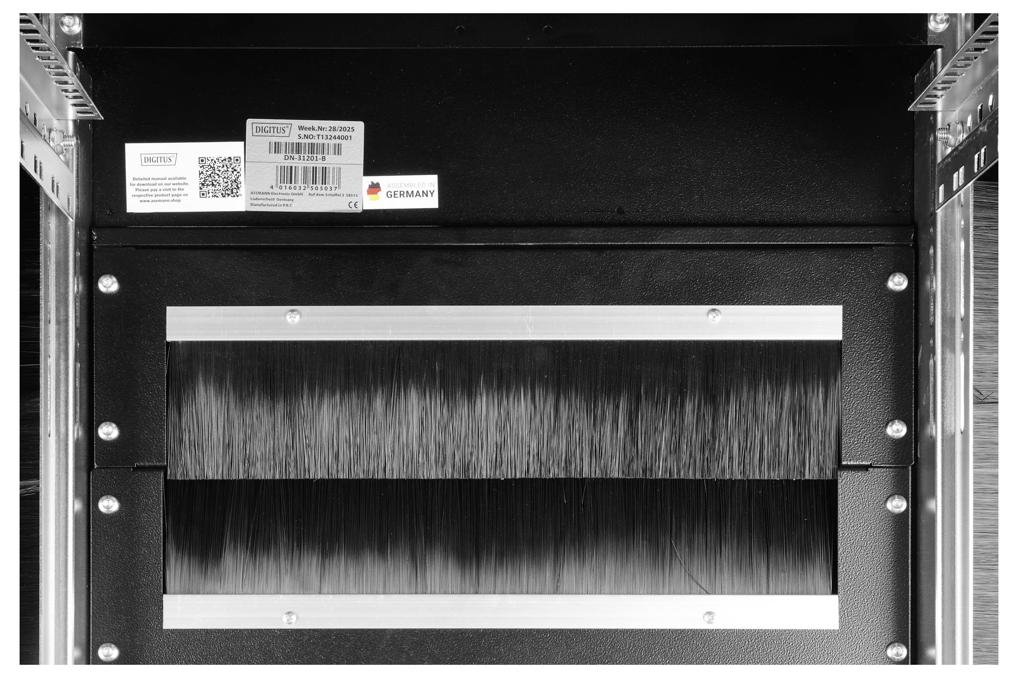 Ein rechteckiges Maschinenteil für industrielle Anwendungen mit Identifikationsetiketten, ausgestattet mit einer zentralen, bürstenähnlichen Komponente, die zur Materialverarbeitung verwendet wird.
