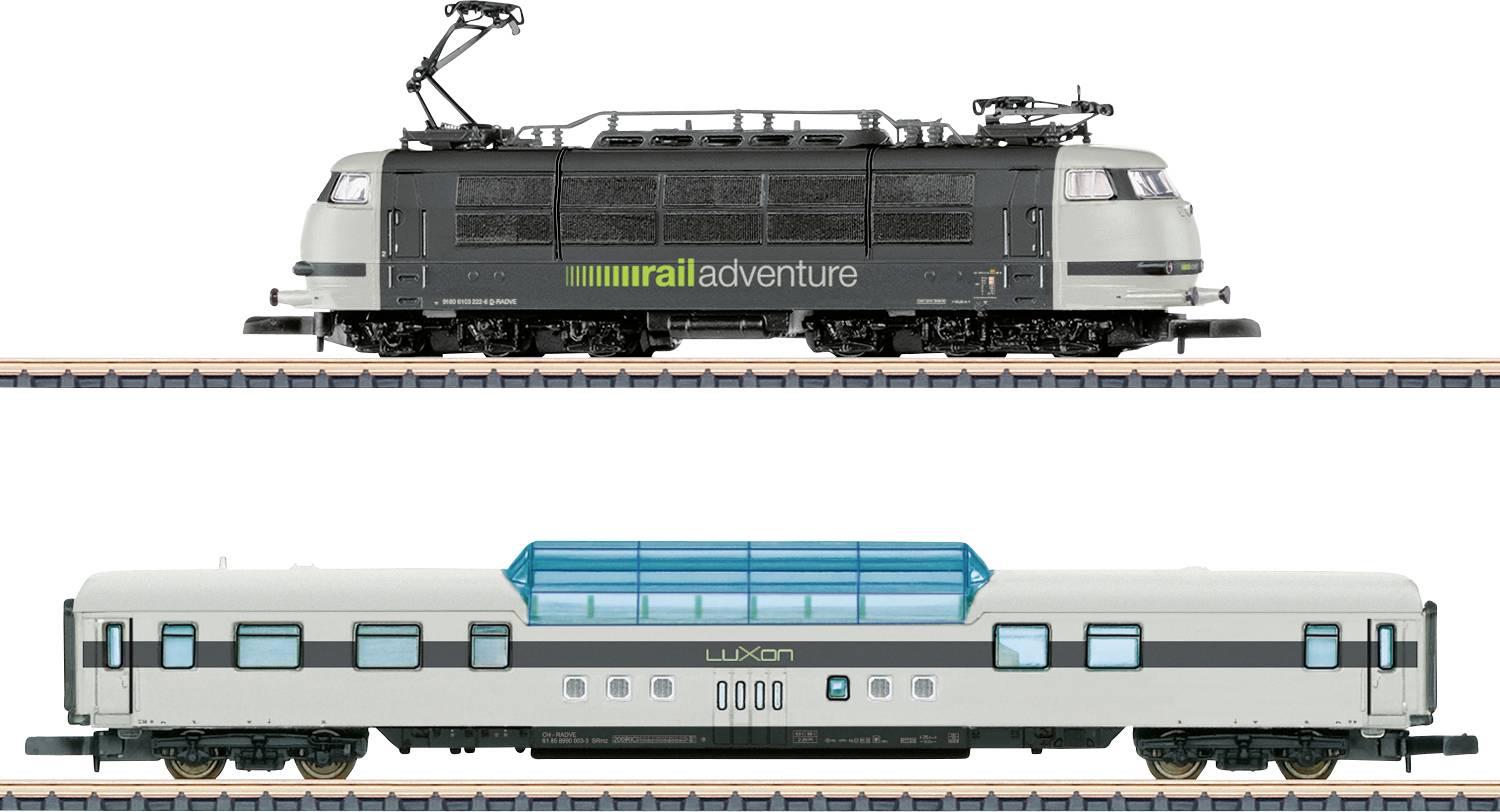 Modelleisenbahnen auf parallelen Gleisen; oben eine schwarze Lokomotive mit der Aufschrift „railadventure", unten ein weißer Personenwagen mit der Aufschrift „LUXON".