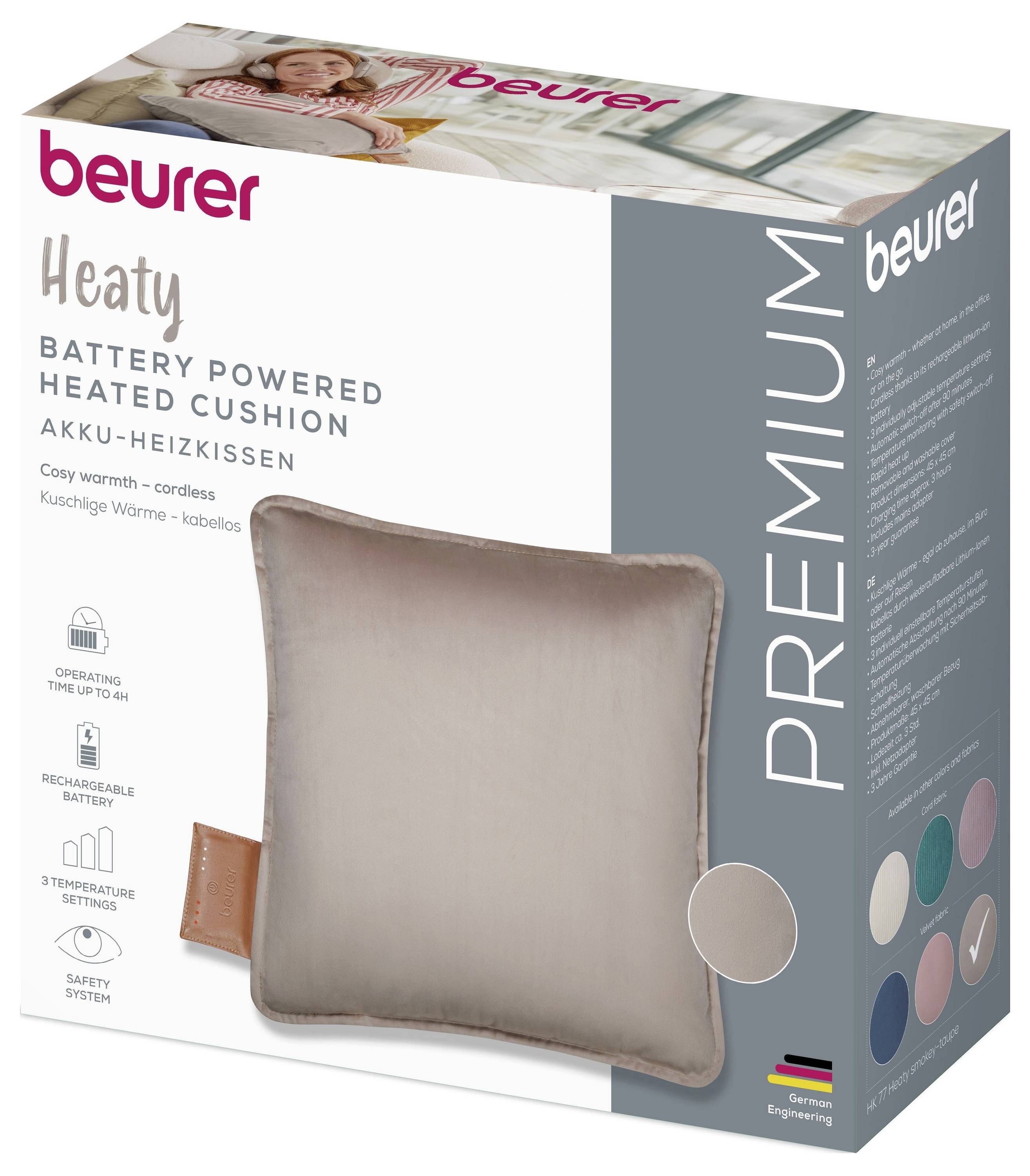 „Beurer Heaty" batteriebetriebenes beheiztes Kissen-Verpackung. Merkmale sind USB-Ladung, Sicherheitssystem, schnurlose Wärmung. Bilder des Kissens und Farboptionen werden angezeigt.