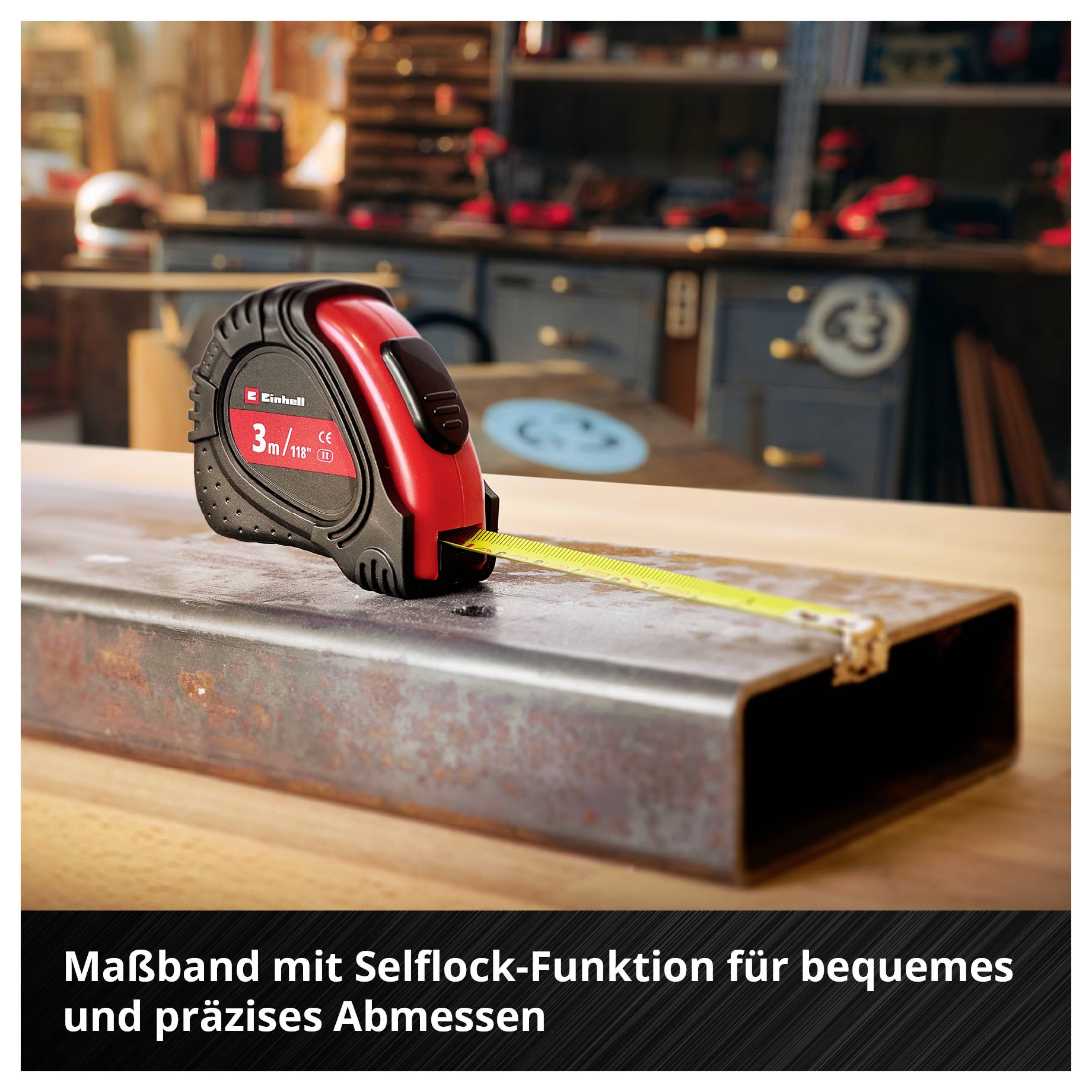 Ein Maßband liegt auf einem Metallträger in einer Werkstatt. Es zeigt 3 Meter Länge an und hat eine Selbstarretierungsfunktion.