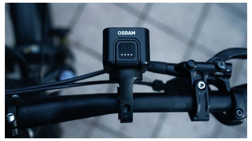 Moto G 5G Smartphone mit Motorola-Logo auf dem Bildschirm, das sein schlankes schwarzes Design mit orangem und blauem abstraktem Hintergrund zeigt.