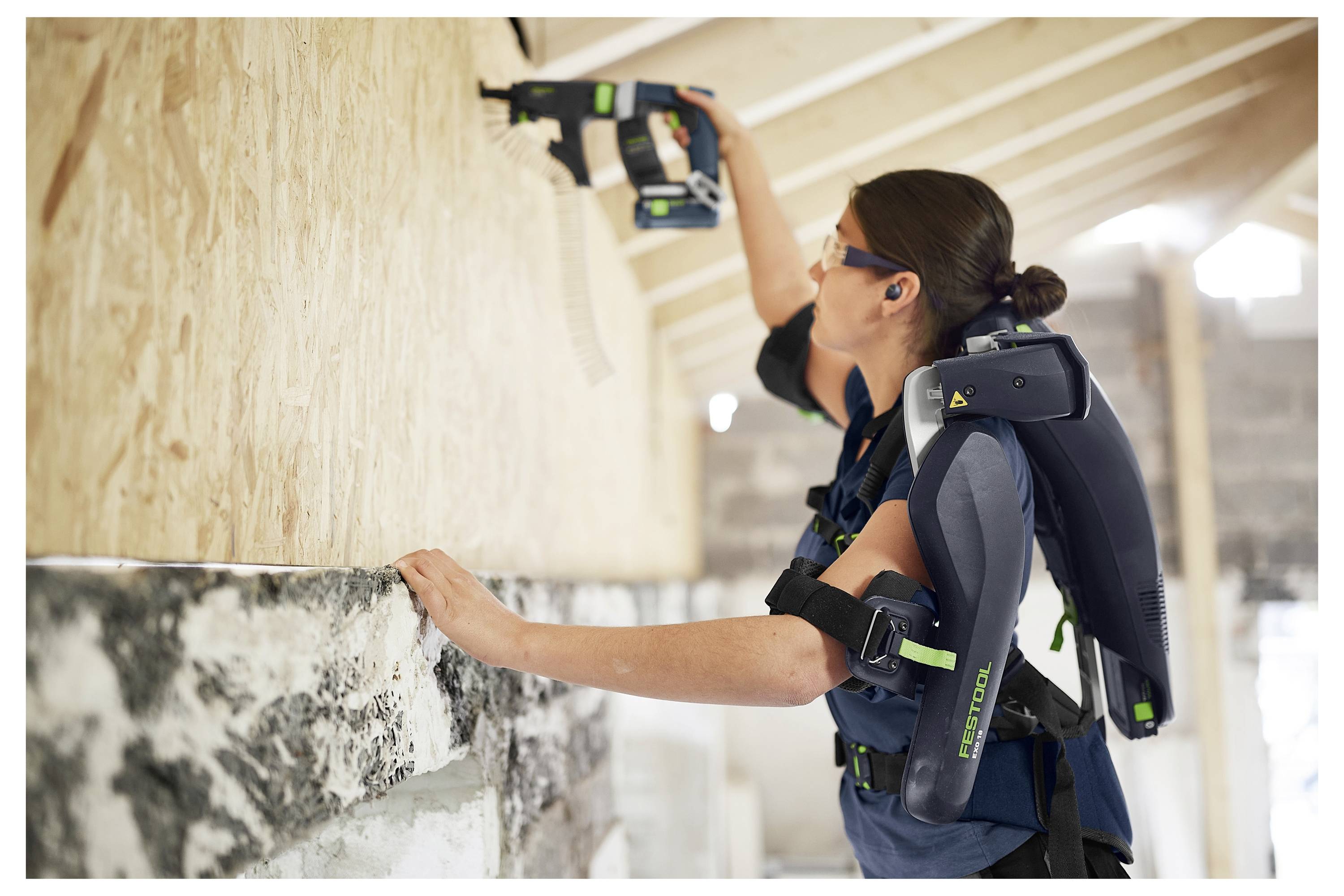 Ein an der Wand befestigtes Kabelführungssystem, das ein flexibles Kabel mit grünen und schwarzen Segmenten hält und eine geordnete Kabelführung gewährleistet.