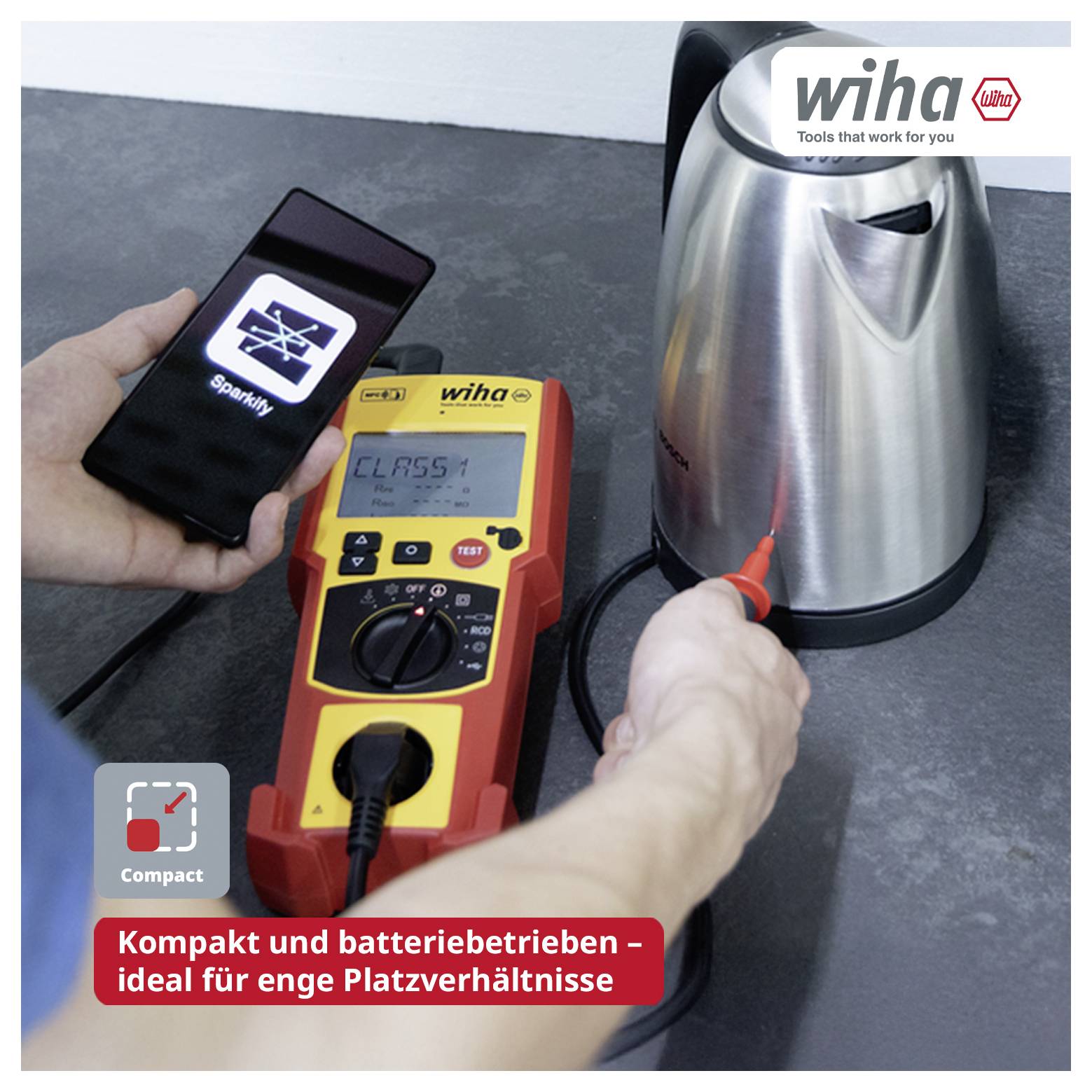 Hand hält Smartphone mit Funkensymbol und prüft einen Wasserkocher mit kompaktem wiha-Messgerät; Hinweis: 'Kompakt und batteriebetrieben - ideal für enge Platzverhältnisse'.