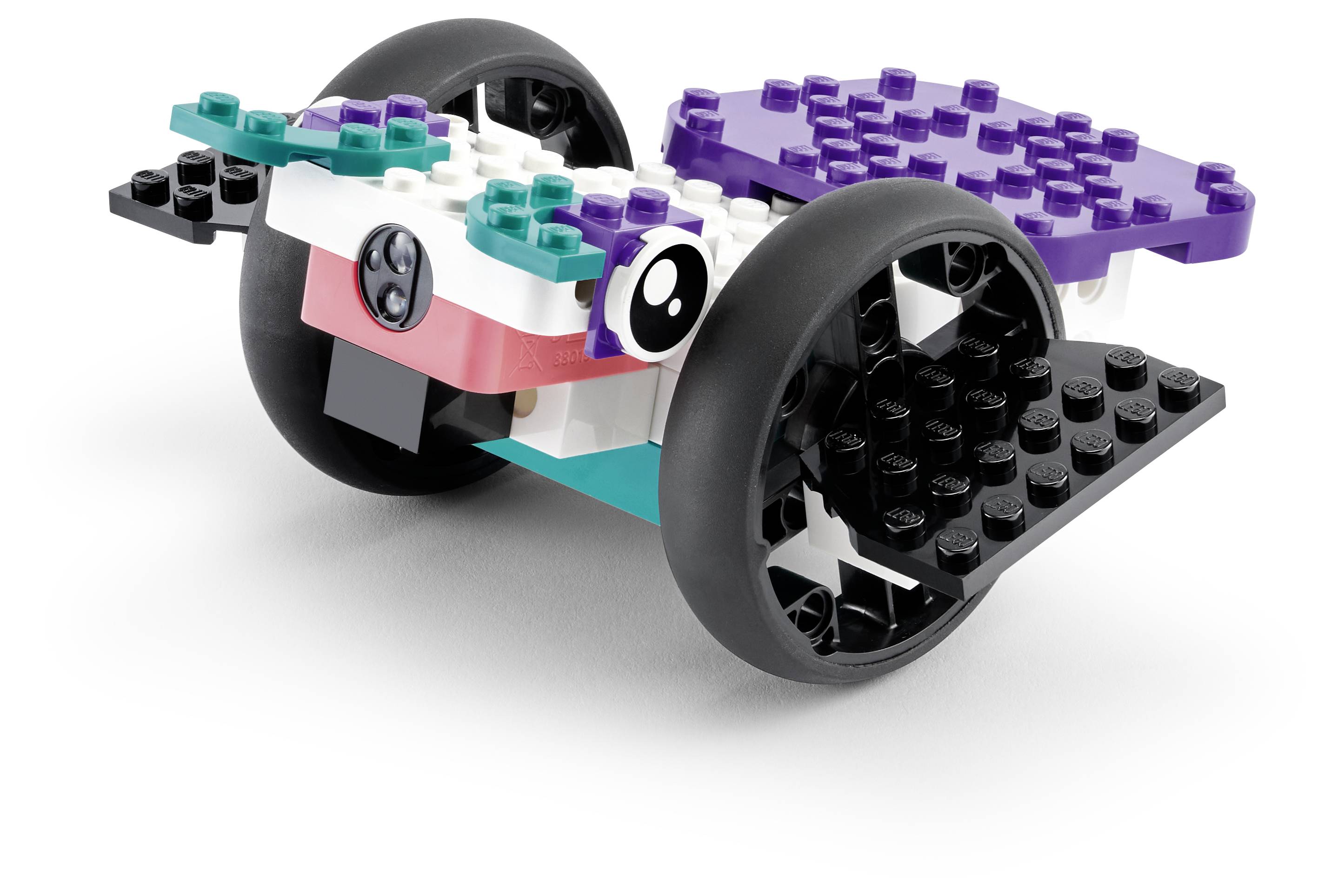 Ein kleiner fahrbarer Roboter aus farbenfrohen, ineinandergreifenden Bausteinen mit schwarzen Rädern und einem violetten Oberteil, der einer verspielten Kreatur ähnelt.