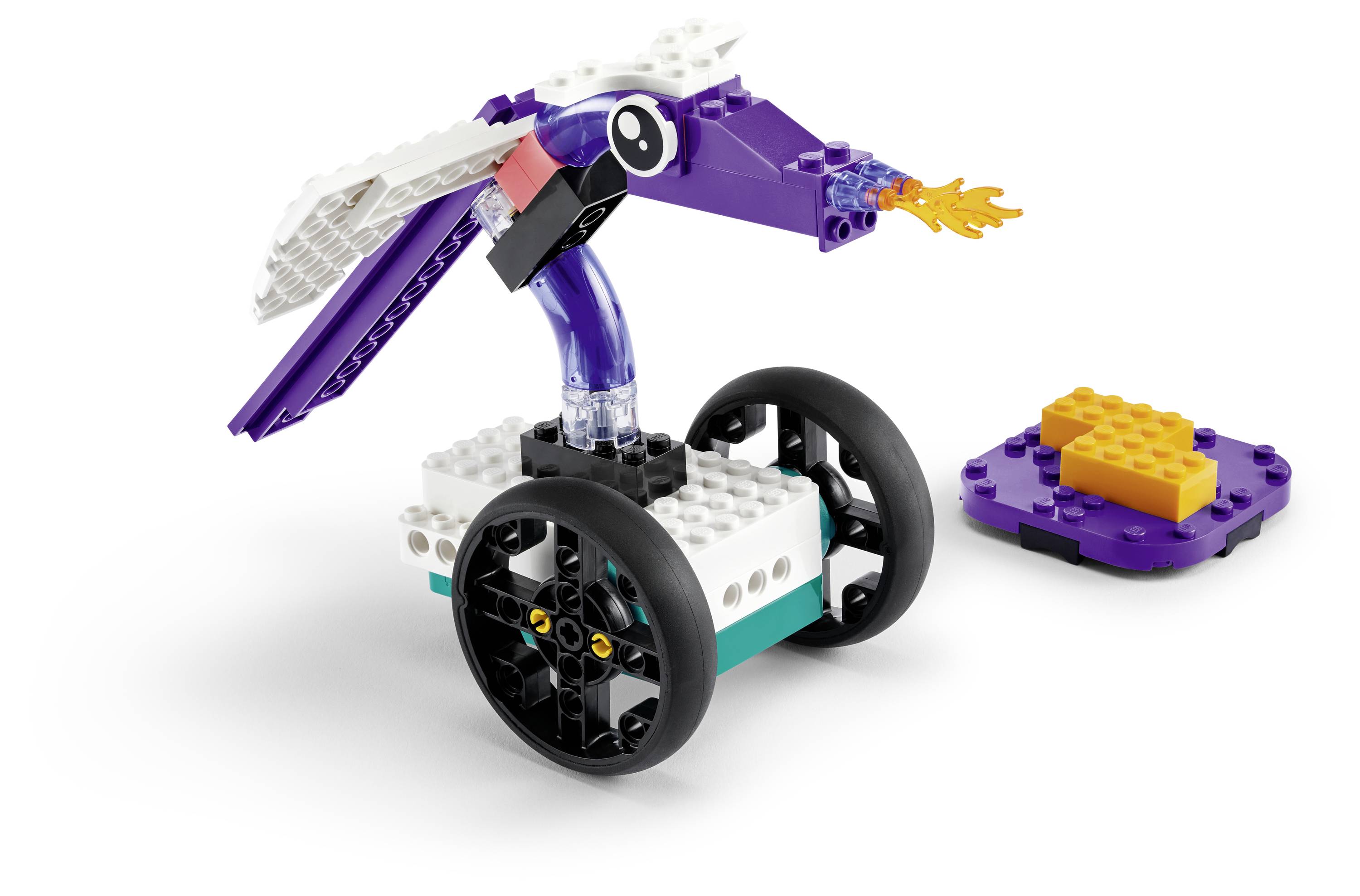 Ein violett-weißer Robotervogel mit Rädern, ausgestattet mit einem feurigen Schnabel-Zubehör, neben einem kleinen rechteckigen, orangefarbenen LEGO-Stein.