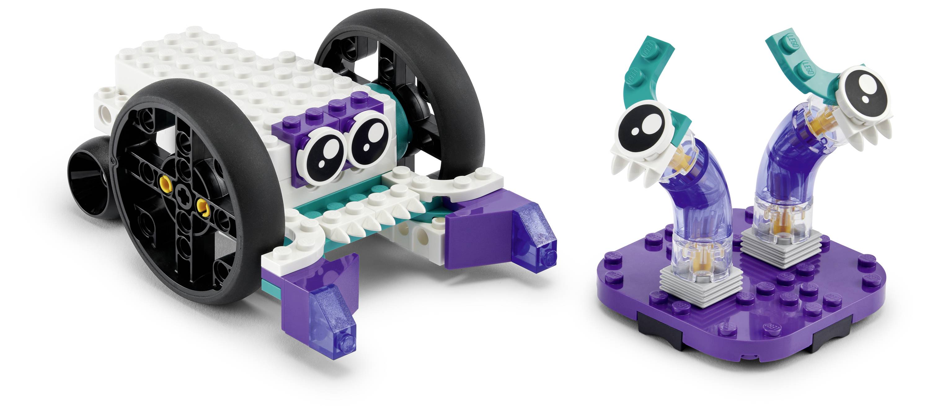 Ein kleiner LEGO-Roboter mit großen Rädern und Augen neben einer separaten Basis mit zwei gekrümmten, augenähnlichen Strukturen auf einer violetten Basis.