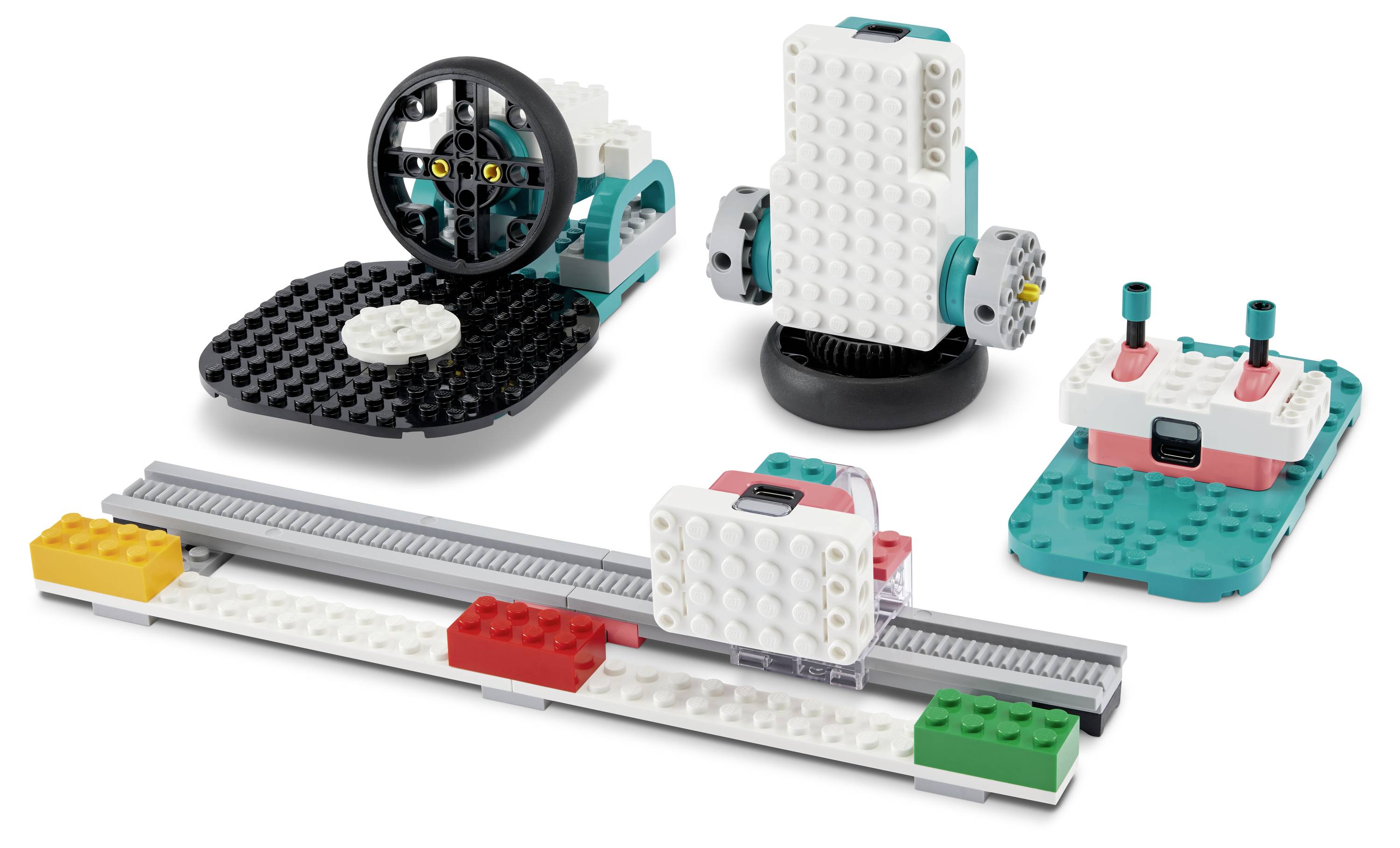 LEGO-Roboterkomponenten auf einer ebenen Fläche angeordnet, einschließlich Räder, einer weißen Basis und bunten Verbindungsteilen, was auf einen modularen Aufbau hindeutet.