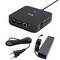Eine schwarze AV-Medienerf­assungsbox mit verschiedenen Anschlüssen, einschließlich HDMI, LAN und USB, zusammen mit Stromkabeln und einem Adapter.
