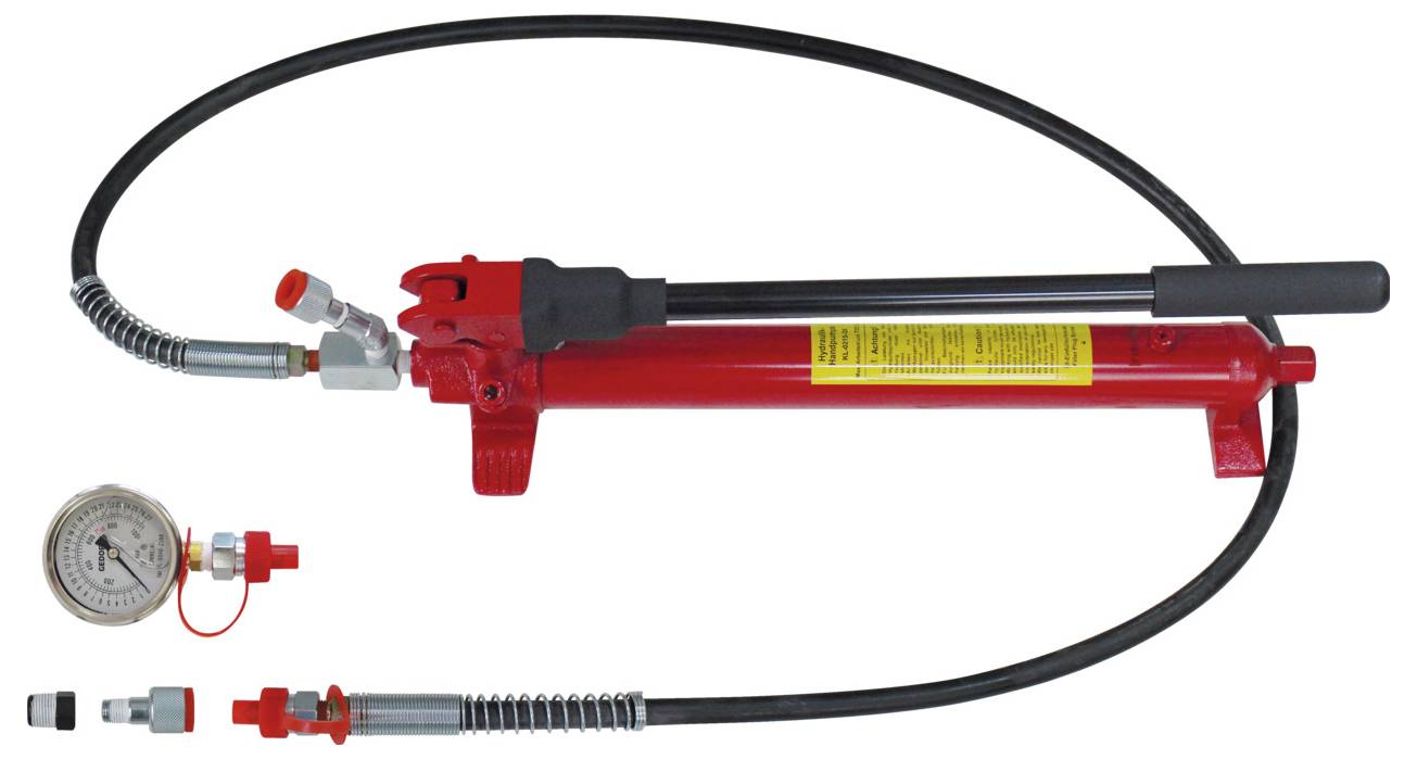 Eine rote hydraulische Pumpe mit schwarzem Schlauch, Manometer und verschiedenen Anschlüssen, verwendet zur Erzeugung von Hochdruck in Hydrauliksystemen.