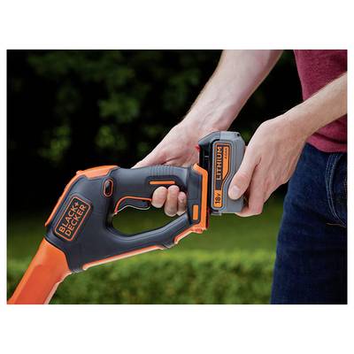 Eine Person setzt eine 18-V-Lithium-Batterie in ein BLACK+DECKER-Gartengerät vor einem unscharfen natürlichen Hintergrund ein.