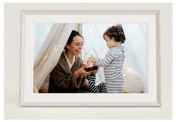 Eine Frau und ein Kind in Pyjamas befinden sich in einem gemütlichen Zelt. Die Frau lächelt, während sie eine leuchtende Kugel hält und sich mit dem Kind auseinandersetzt.