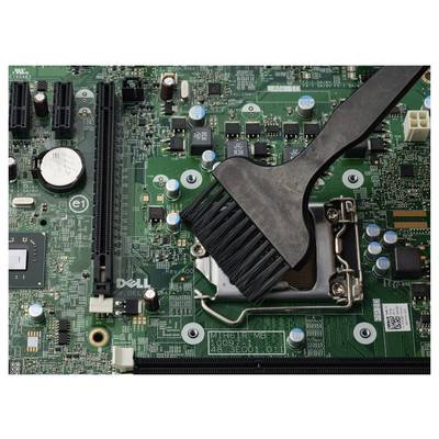 Nahaufnahme einer Computermainboard, das mit einer Bürste über dem CPU-Sockel und in der Nähe befindlichen Komponenten gereinigt wird.