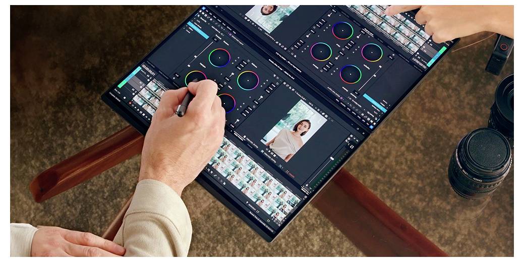Zwei Personen bearbeiten Fotos auf einem Dual-Screen-Laptop mit Stylus und Touch.