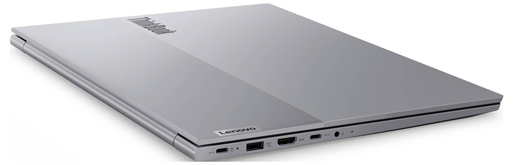 Ein geschlossener silberner Lenovo-Laptop mit Anschlüssen an der Seite, einschließlich USB, HDMI und Kopfhöreranschluss. Lenovo-Logo auf dem Deckel sichtbar.