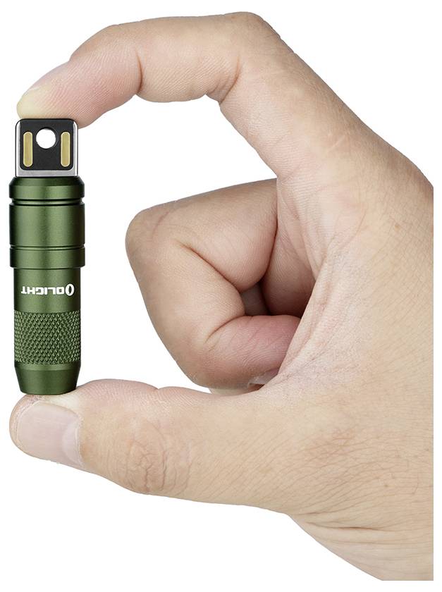 Eine Hand, die eine kleine grüne Taschenlampe mit USB-Anschluss der Marke „OLIGHT" vor weißem Hintergrund hält.