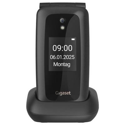 Ein schwarzes Klapphandy auf einer Ladestation zeigt auf dem Bildschirm "09:00", "06.01.2025", "Montag" an.