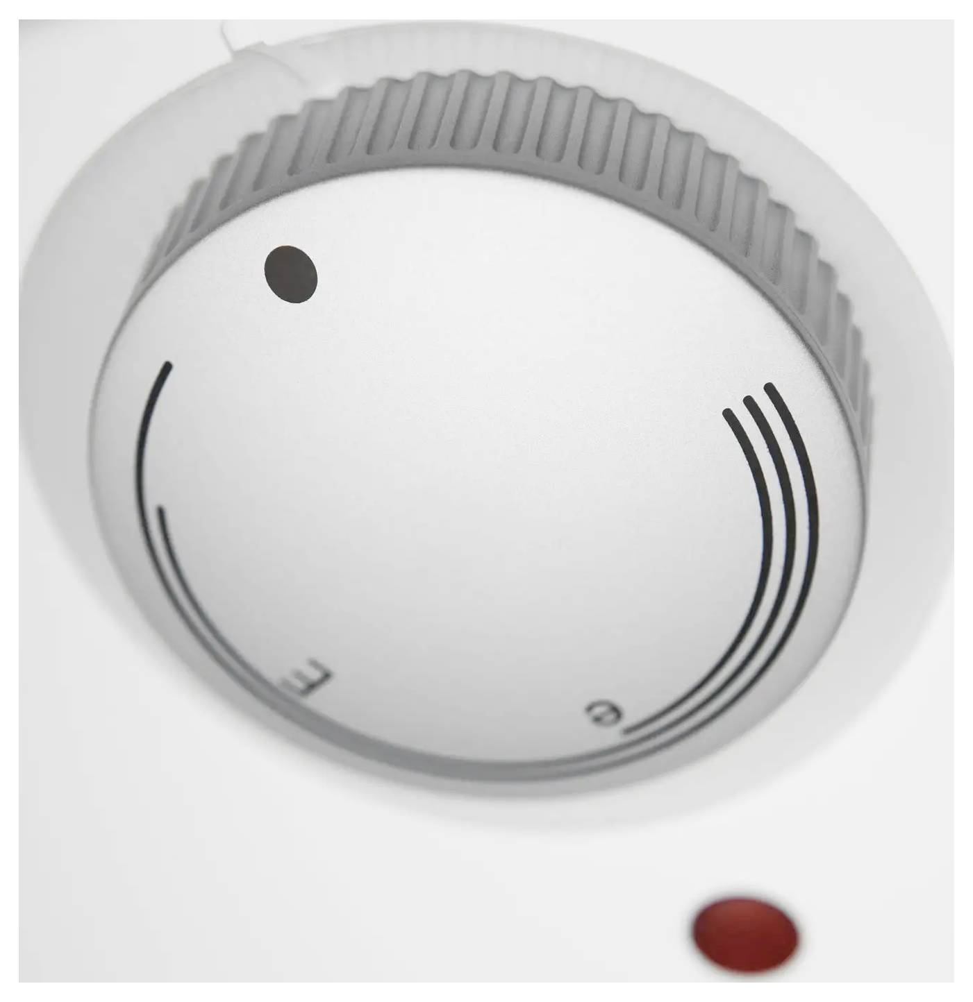 Eine Nahaufnahme eines Thermostats mit Temperatureinstellungen, Linien und einem Punktanzeiger, der auf die Markierung „E" ausgerichtet ist.