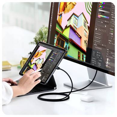 Eine Person benutzt ein Tablet, das mit einem großen Monitor verbunden ist, wobei beide ein buntes digitale Kunstsoftware-Programm mit Bearbeitungswerkzeugen und lebendiger Grafik anzeigen.