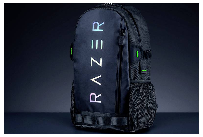 Ein schwarzer Razer-Rucksack mit "RAZER"-Text in Farbverlauf auf der Vorderseite, mit seitlichen Netztaschen und grünen Akzenten vor dunklem Hintergrund.