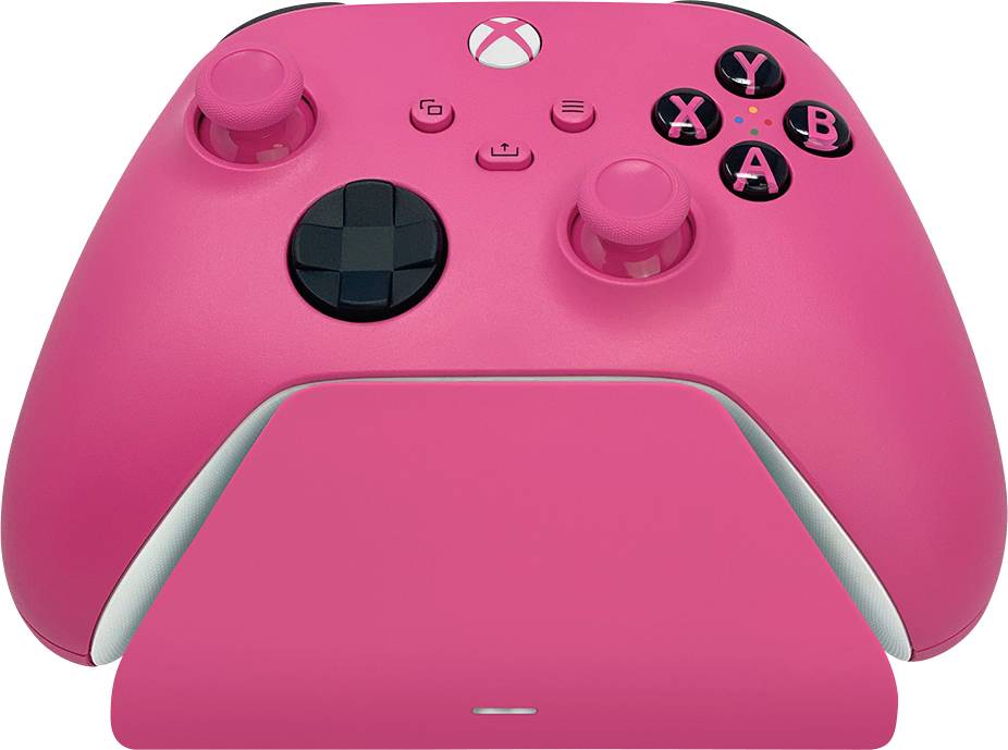 Ein lebendiger rosa Videospiel-Controller mit Knöpfen mit den Bezeichnungen „A", „B", „X", „Y" und Richtungspad, das auf einem passenden rosa Ständer ruht.