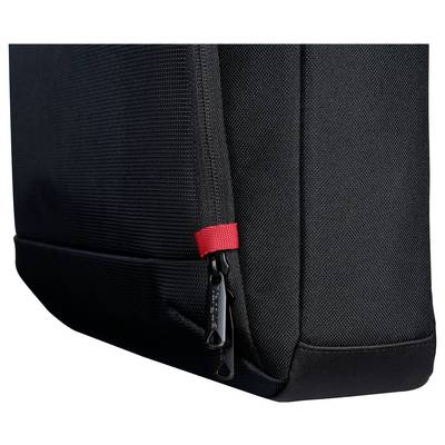 Nahaufnahme einer schwarzen Stoff-Tasche oder eines Rucksacks-Ecke mit einem Reißverschluss und einem kleinen roten Zugriegel auf weißem Hintergrund.